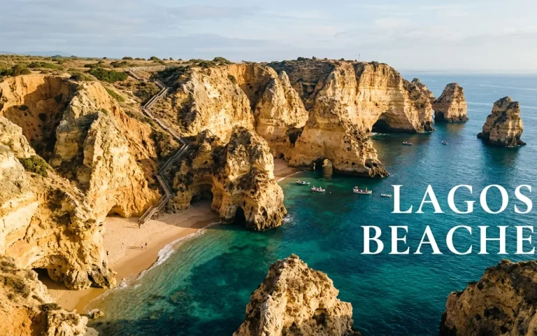 Aerial view of a golden cliff-framed cove with turquoise water and a wooden staircase, showcasing the best lagos beaches.