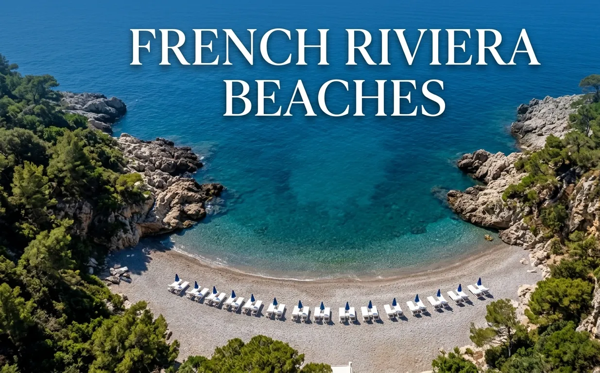 An aerial view of an exclusive French Riviera beach club with white sunbeds on a pebble shore and clear turquoise water.